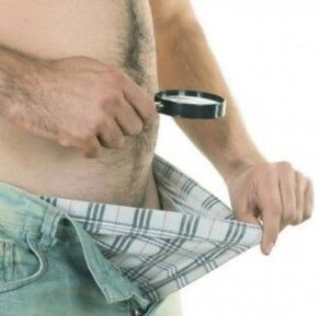 Un homme baisse les yeux sur son pantalon et veut agrandir son pénis avec du gel